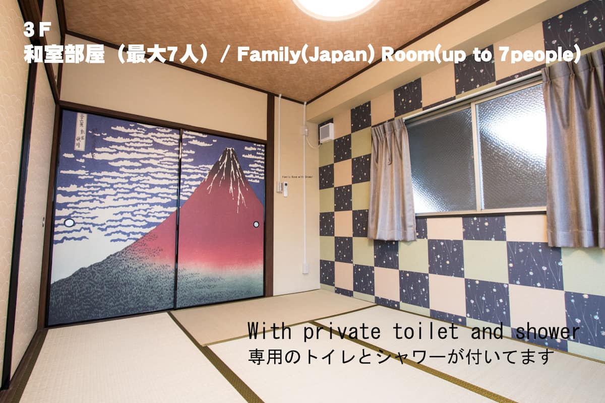 A traditional Japanese room with tatami flooring, a shoji screen depicting Mount Fuji, and a checkered wall pattern. It includes a private toilet and shower.