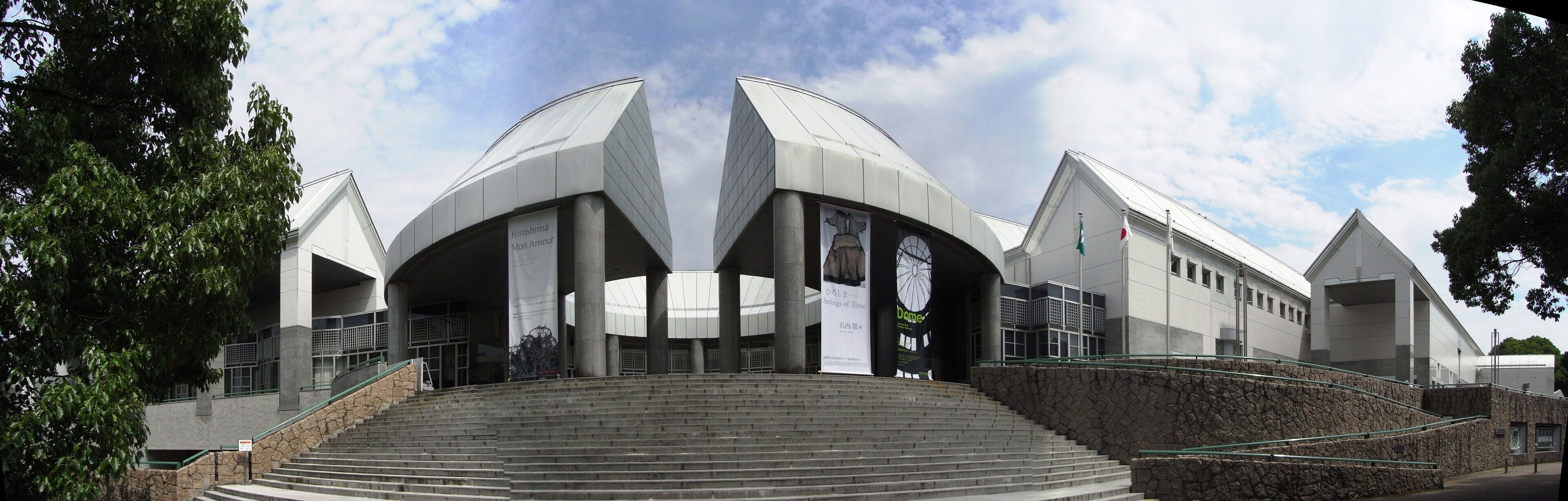 A modern building with a unique architectural design, featuring a central dome and multiple entry points.