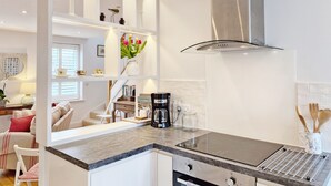 A modern kitchen with white cabinetry, a stainless steel range hood, and a built-in stove. - Castleton , Chichester  - sleeps 2 guests  in 1 bedroom (Chichester)
