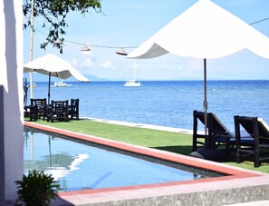 Una piscina al aire libre, camas de piscina gratis, sombrillas