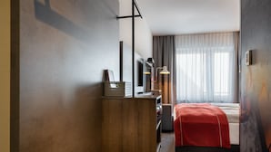 A hotel room with a bed, a desk with a lamp, a wardrobe, and a large window with curtains. - Holiday Inn - the niu, Hide Berlin Friedrichshain by IHG (Berlin)