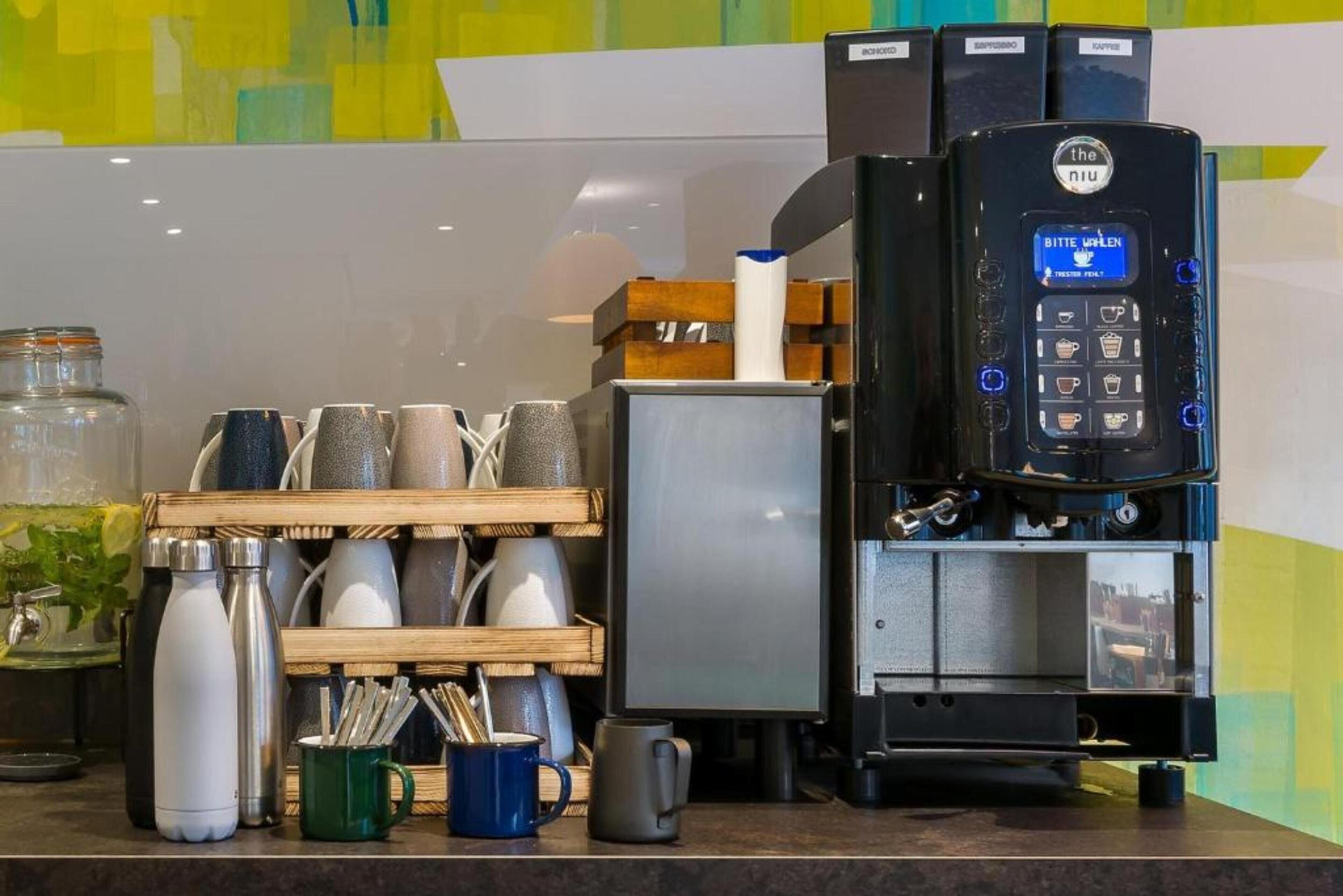 A coffee machine with a digital display, a coffee grinder, and a mug rack with various cups and mugs.