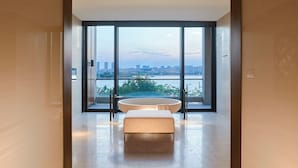 Un baño moderno con bañera, ventanas amplias y vistas a la ciudad.