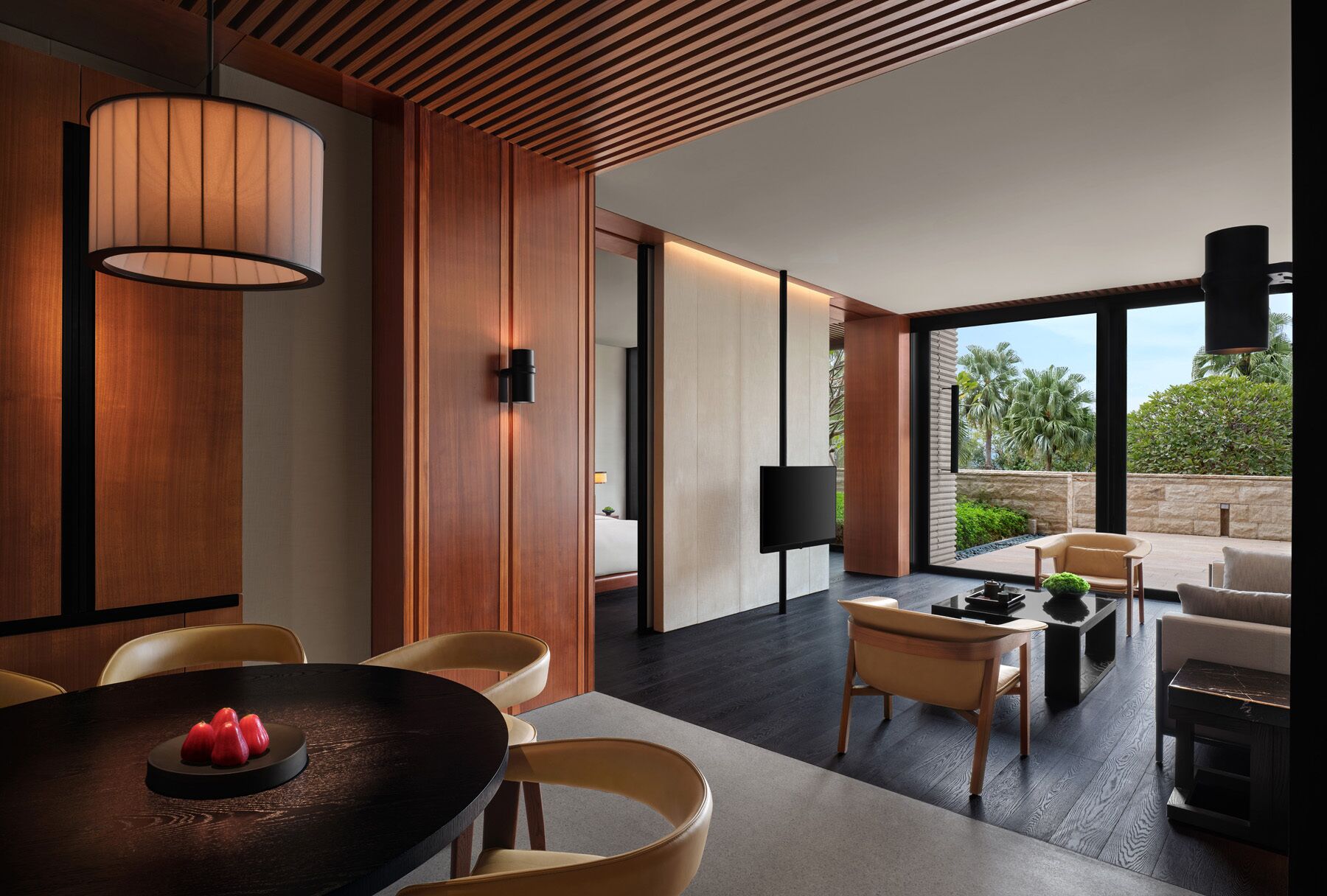 Un interior moderno con comedor, televisor de pantalla plana y vistas al exterior.