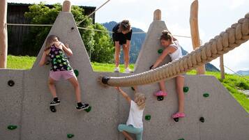 A climbing wall with multiple routes and wooden poles.