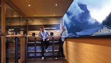 Un intérieur moderne avec un plafond en bois, un mur en verre et une vue sur une montagne.