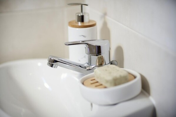 A bathroom sink with a chrome faucet and a soap dish.