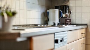 Une cuisine moderne avec des carreaux blancs, une machine à café et un appareil électroménager Siemens.