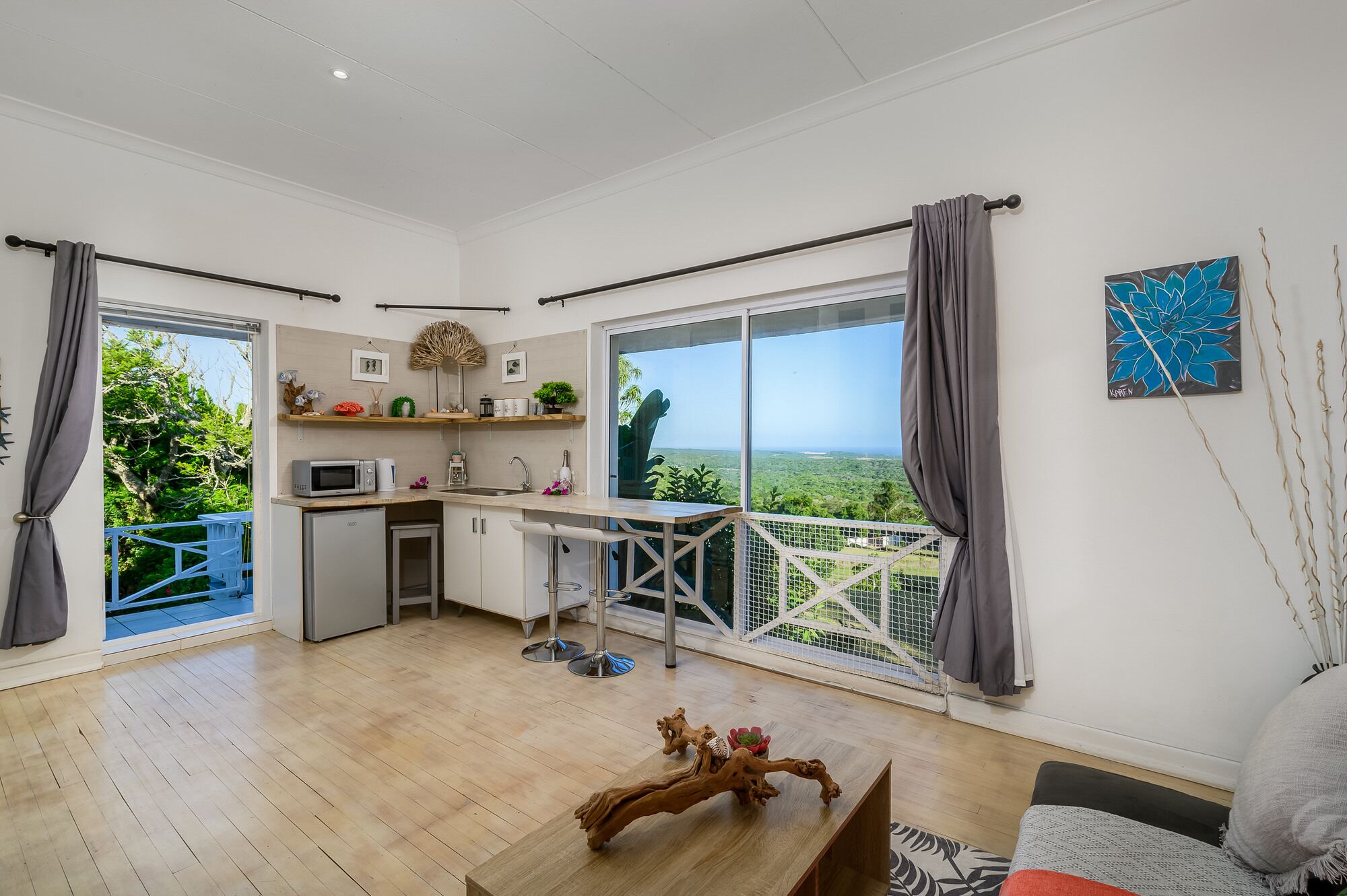 Uma cozinha moderna com vista, uma área de refeições e um espaço de estar com varanda.