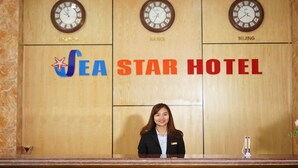 A reception desk at the Sea Star Hotel with clocks displaying London, Hanoi, and Beijing times. - SeaStar Hotel Ha Long (Bai Chay)