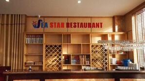 A restaurant interior with wooden shelves, wine racks, and a counter. - SeaStar Hotel Ha Long (Bai Chay)