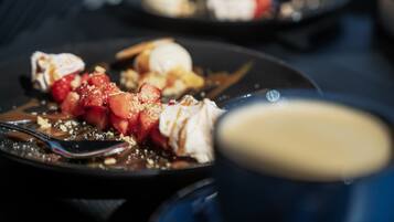 A dessert plate with strawberries, whipped cream, and chocolate sauce.