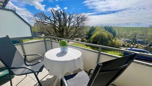 A balcony with a round table, two chairs, and a potted plant. - N 7 (BC.a5) - Stranddomicil Steiner (Büsum)