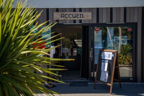 A hotel entrance with a sign reading "ACCUEIL" and a reception desk with a signboard. - Camping le Paradis (Talmont-Saint-Hilaire)