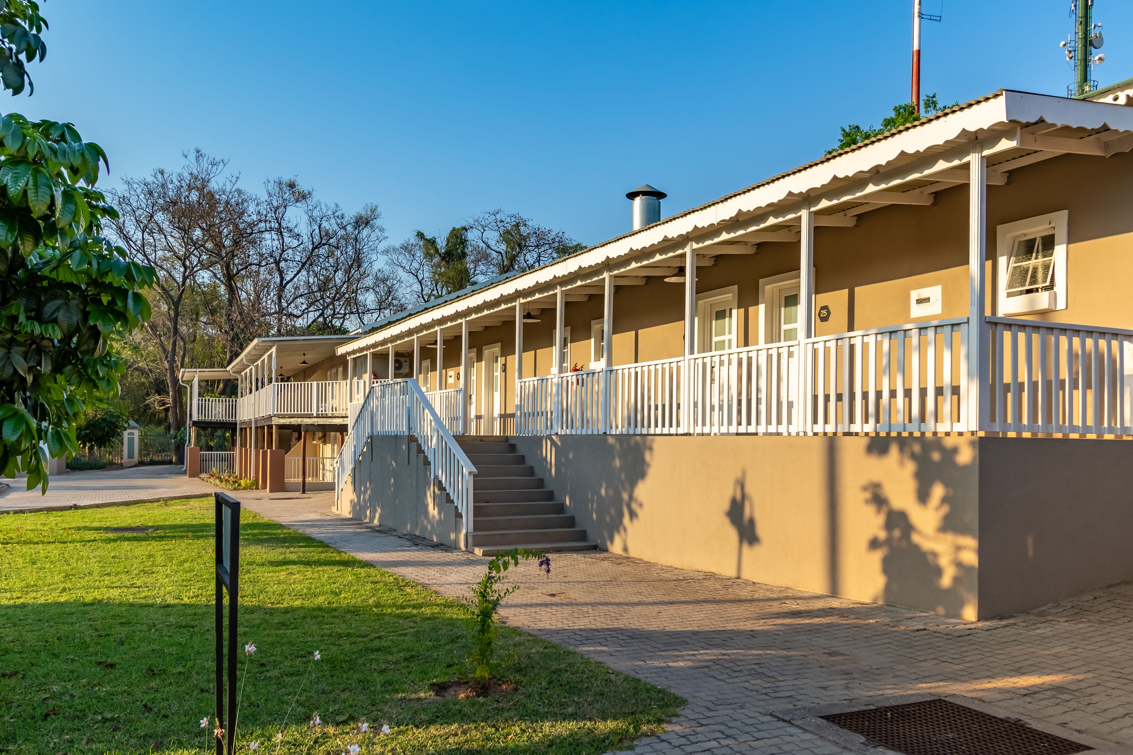 A two-story building with a covered porch and a staircase leading to the upper level.