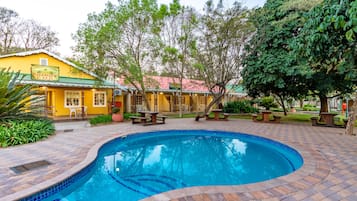 Una piscina al aire libre, sillones reclinables de piscina