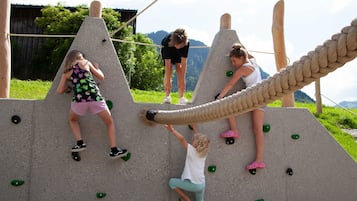 Un mur d’escalade avec plusieurs voies et des poteaux en bois.