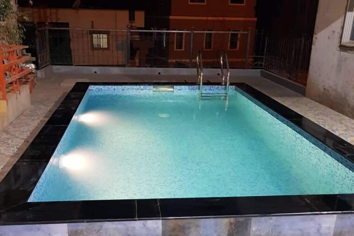 Una piscina rectangular con borde de azulejos y un diseño de mosaicos a su alrededor.