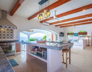 Una cocina espaciosa con una isla grande, vigas de madera y vistas al exterior.