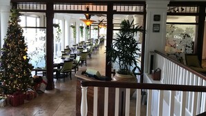 A hotel lobby with a Christmas tree, dining area, and a staircase. - Deluxe Room w/King Bd, Ocean/Pool views, New Furnishings!, No Resort Fee (Lihue)