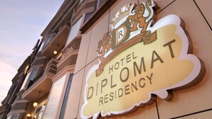A hotel sign with a crest and the name "Hotel Diplomacy Residency". - Hotel Diplomat Residency (New Delhi)