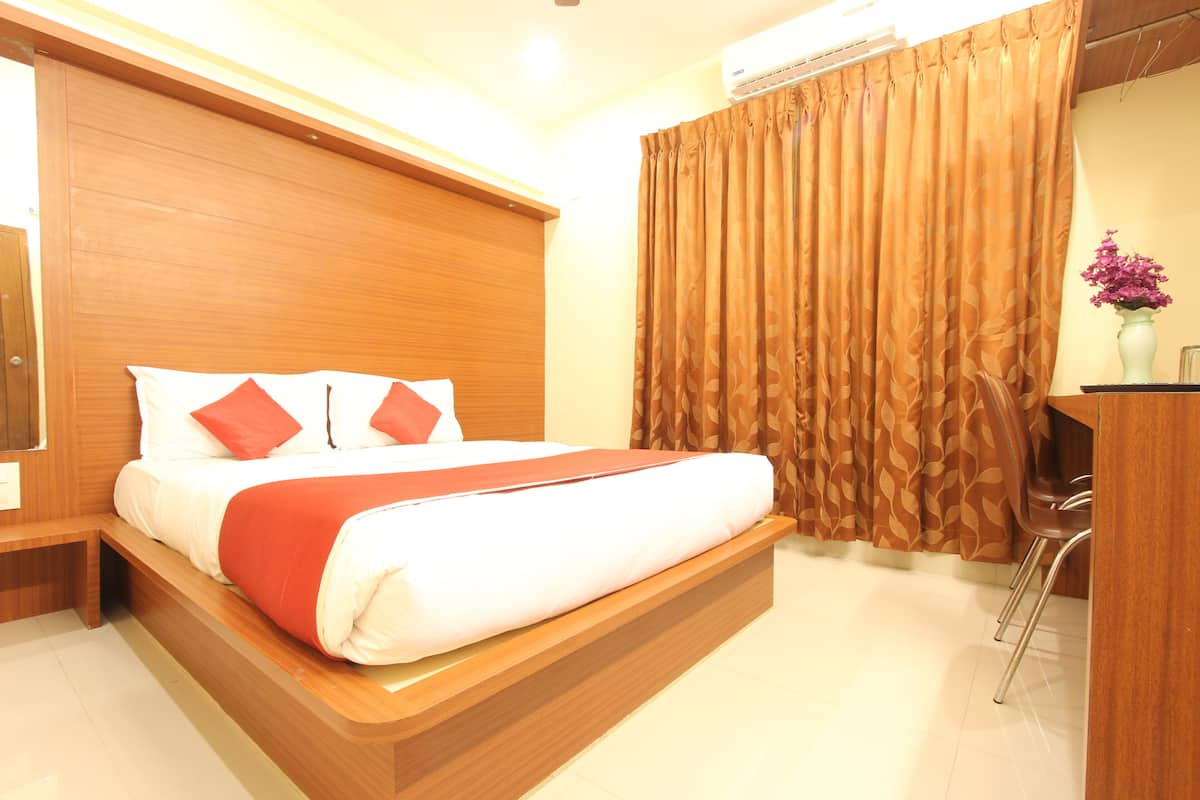 A hotel room with a wooden bed, a desk, and a large window.