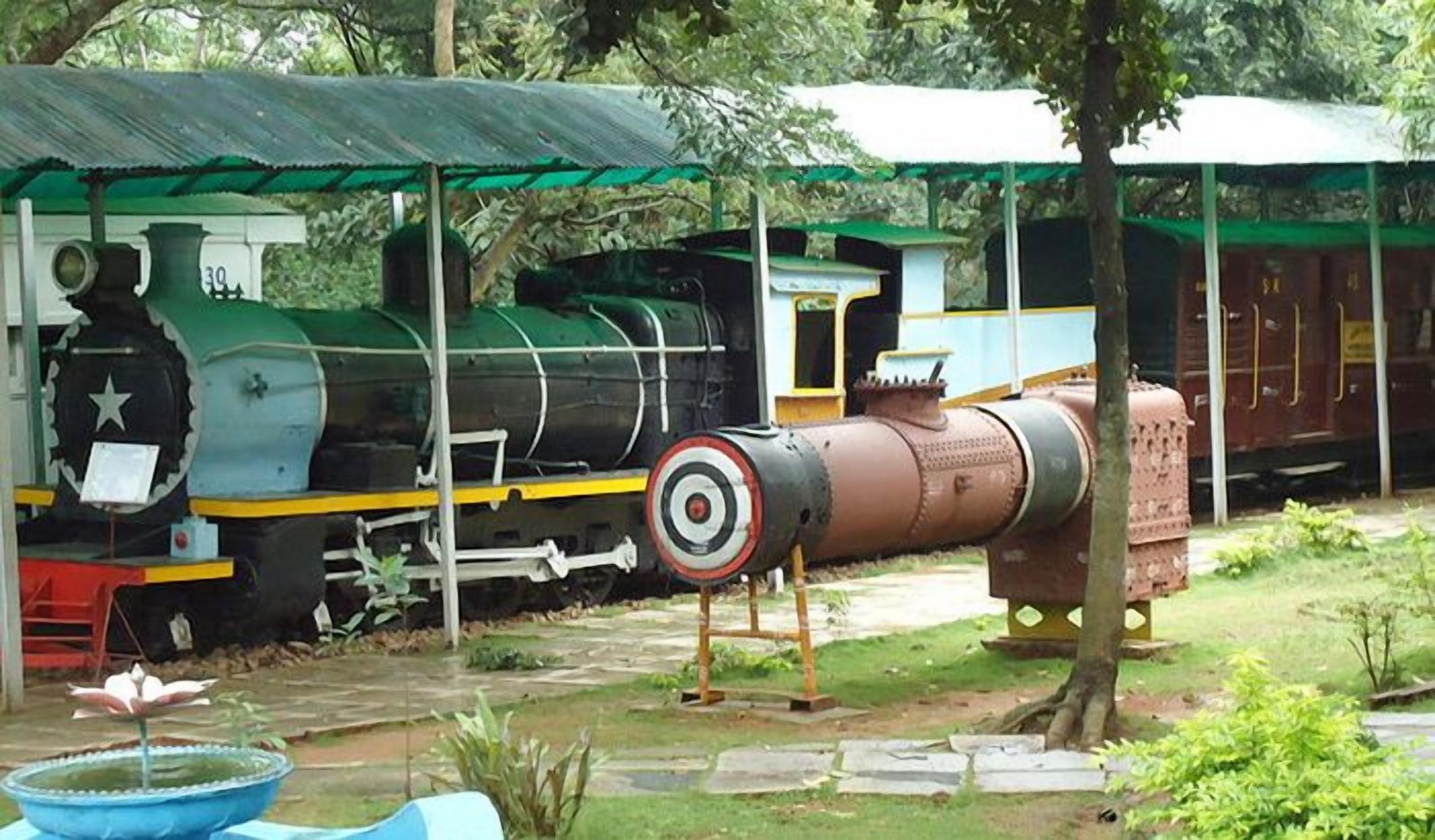 Una locomotiva a vapore d'epoca con esterno verde e nero, fronte rossa e una piccola cabina.