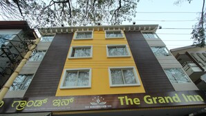 Un edificio con un letrero que dice 'The Grand Inn' y un logo con estrellas y una hoja.