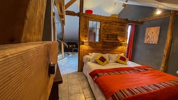 Un dormitorio estilo cabaña de madera acogedor, con cama, almohadas y una manta roja.