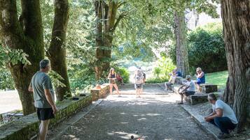 A park with a dirt path, benches, and people.