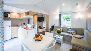 A compact living space with a kitchenette, dining area, and seating area. - Camping le Gibanel (Saint Martial Entraygues)