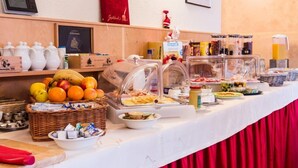 Montaje tipo bufé con diversas opciones de comida, como frutas, pastelería y bebidas.