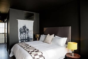 Relax in a serene space with a large bed, a nightstand, and a striking black and white artwork.