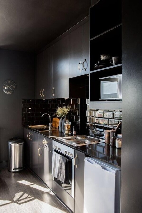 Enjoy cooking in this well-equipped kitchen with an oven, stainless steel sink, and sleek cabinetry.