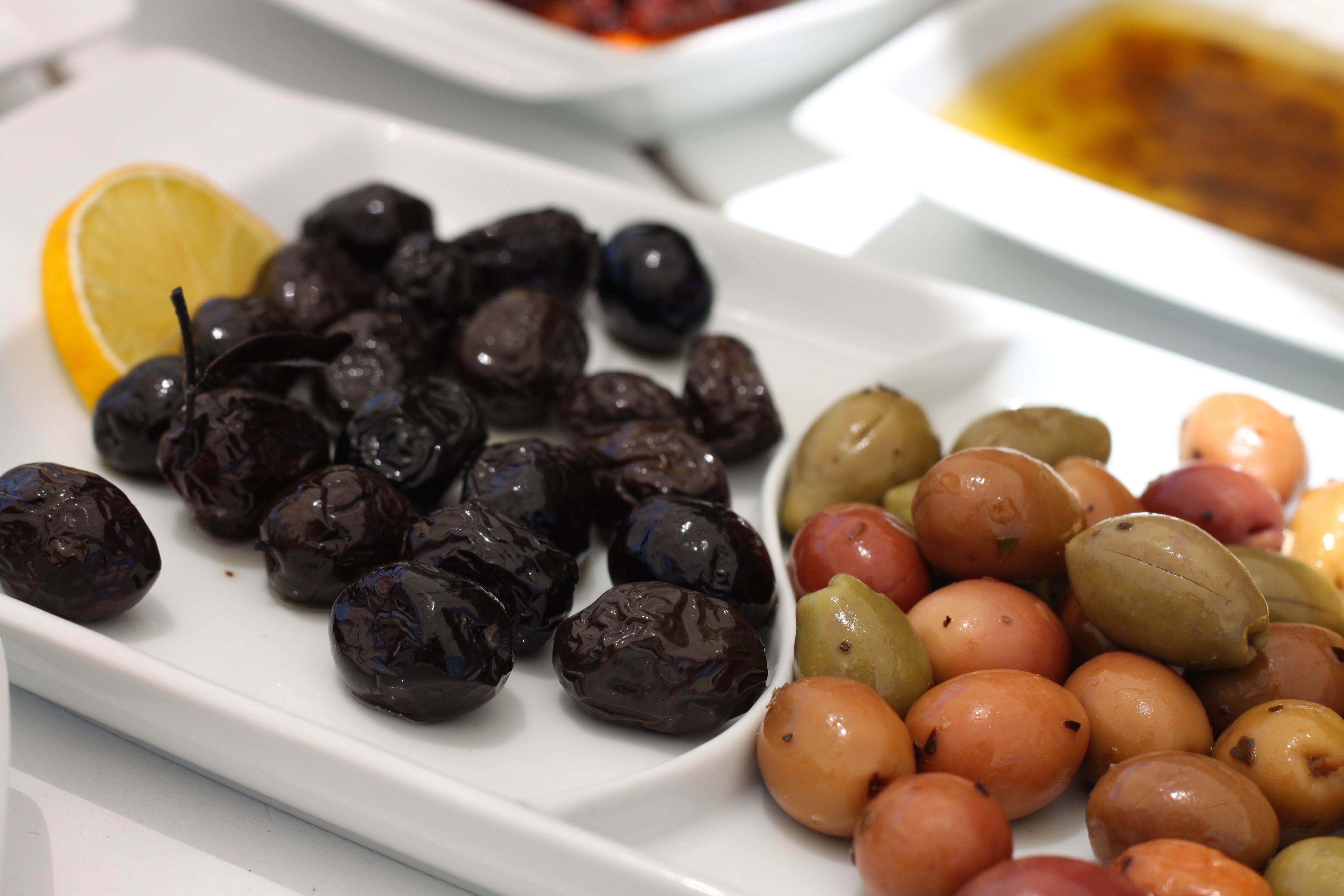 Une assiette d’olives et une tranche de citron.