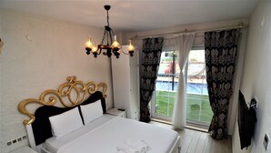 Ein Schlafzimmer mit einem großen Bett, einer Kandelaber und einem Fenster mit Vorhängen.