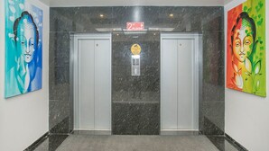 An elevator area with two elevators, a 'No Floor' sign, and a digital display. - OYO 490 Hotel Compact Maple Leaf (Bengaluru)