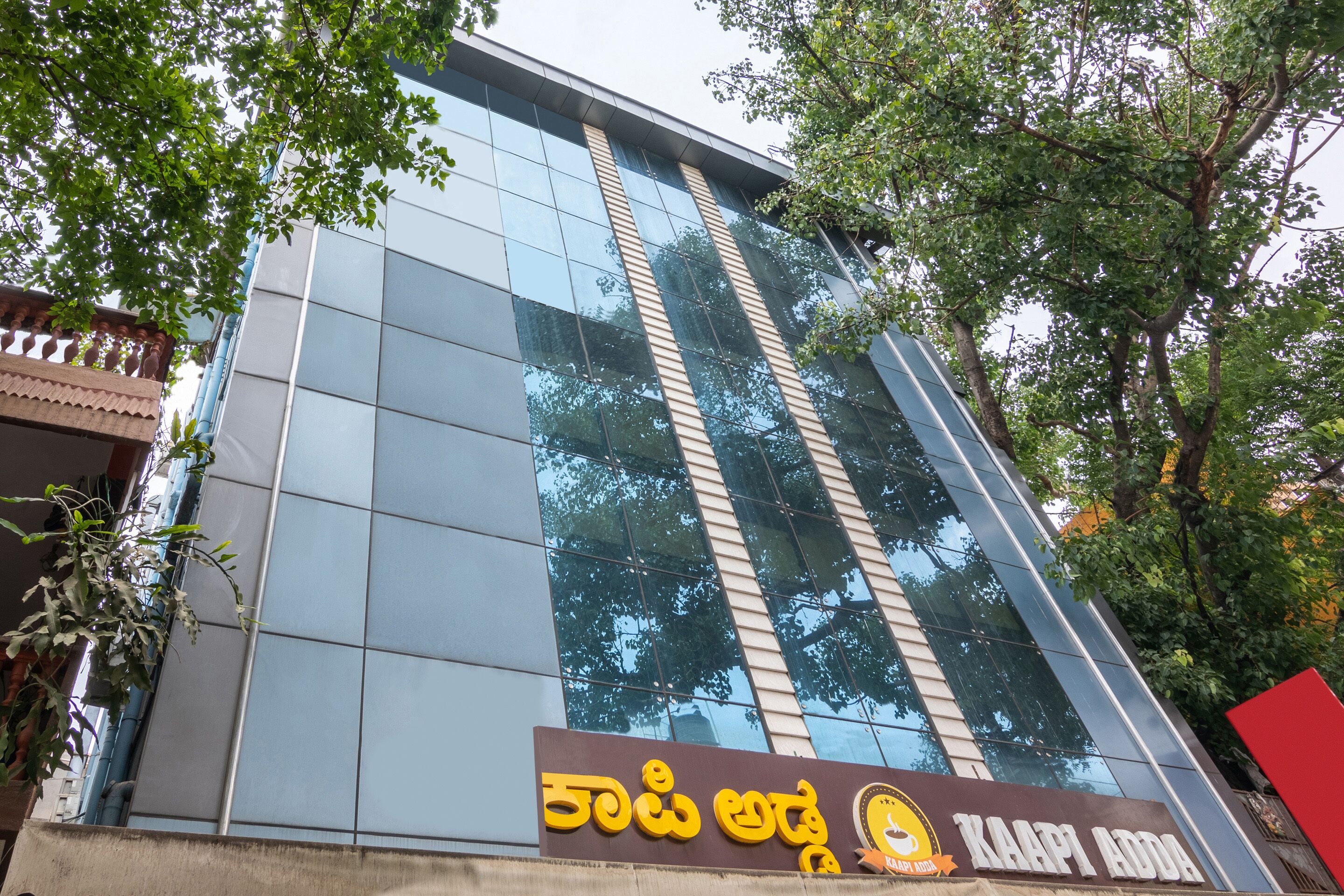 A modern building with large glass windows and a signboard with text in a non-Latin script.