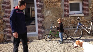 A man and a child near a stone building with a bicycle and a dog. - La Ferme du Bois Paris (Ermenonville-la-Petite)