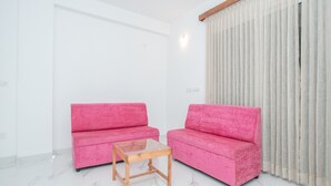 A room with two pink sofas and a small wooden table. - OYO 12045 Dollars Nest (Bengaluru)