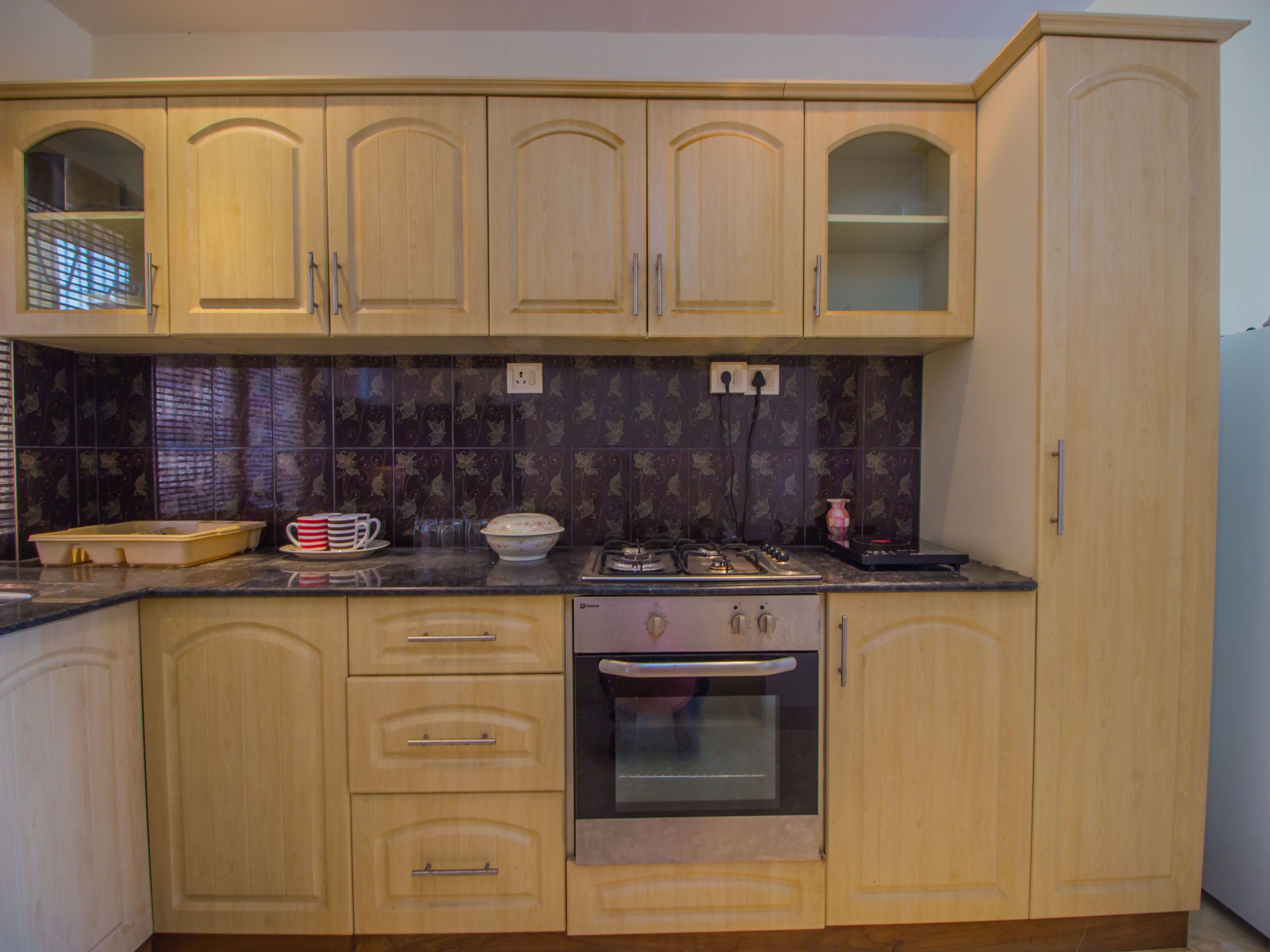 A kitchen with wooden cabinets, a countertop, a stove, and a dishwasher.
