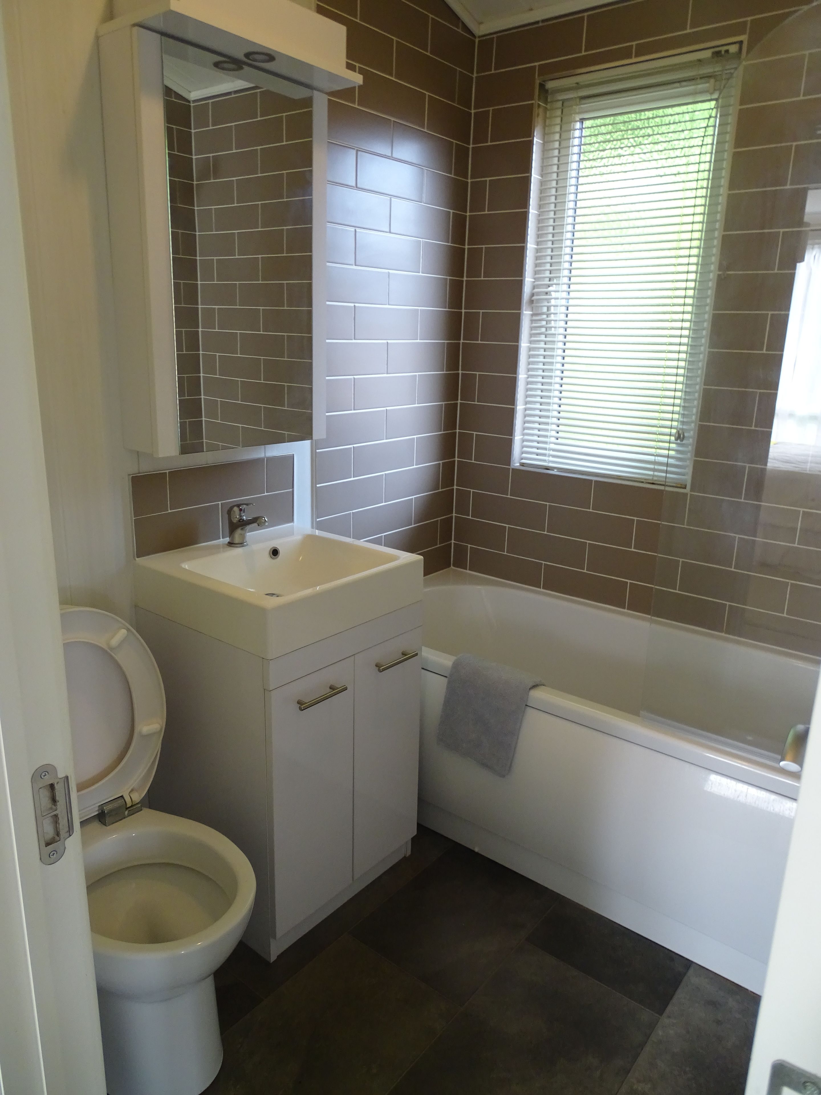A bathroom with a toilet, sink, and bathtub.
