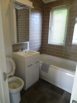Un baño con inodoro, lavabo y bañera.
