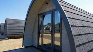 Un bâtiment moderne doté d’un toit incurvé et de grandes portes vitrées.