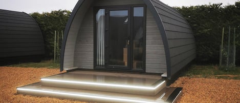 Een modern, gelijkvloers gebouw met een gebogen dak en een glazen deuropening.