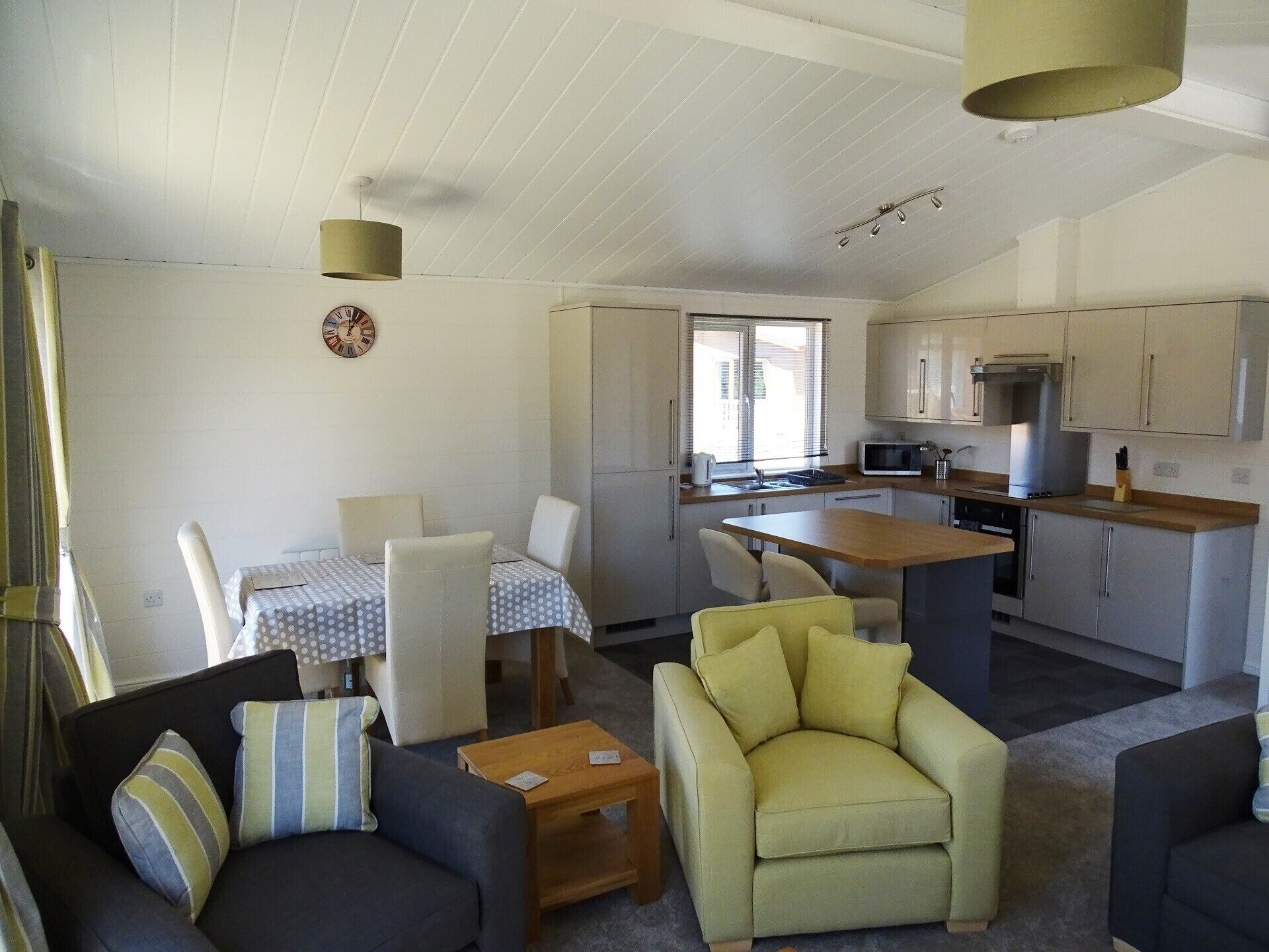 Un espacio habitable compacto con comedor, kitchenette y zona de estar.