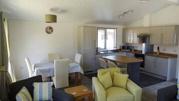 Un espacio habitable compacto con comedor, kitchenette y zona de estar.