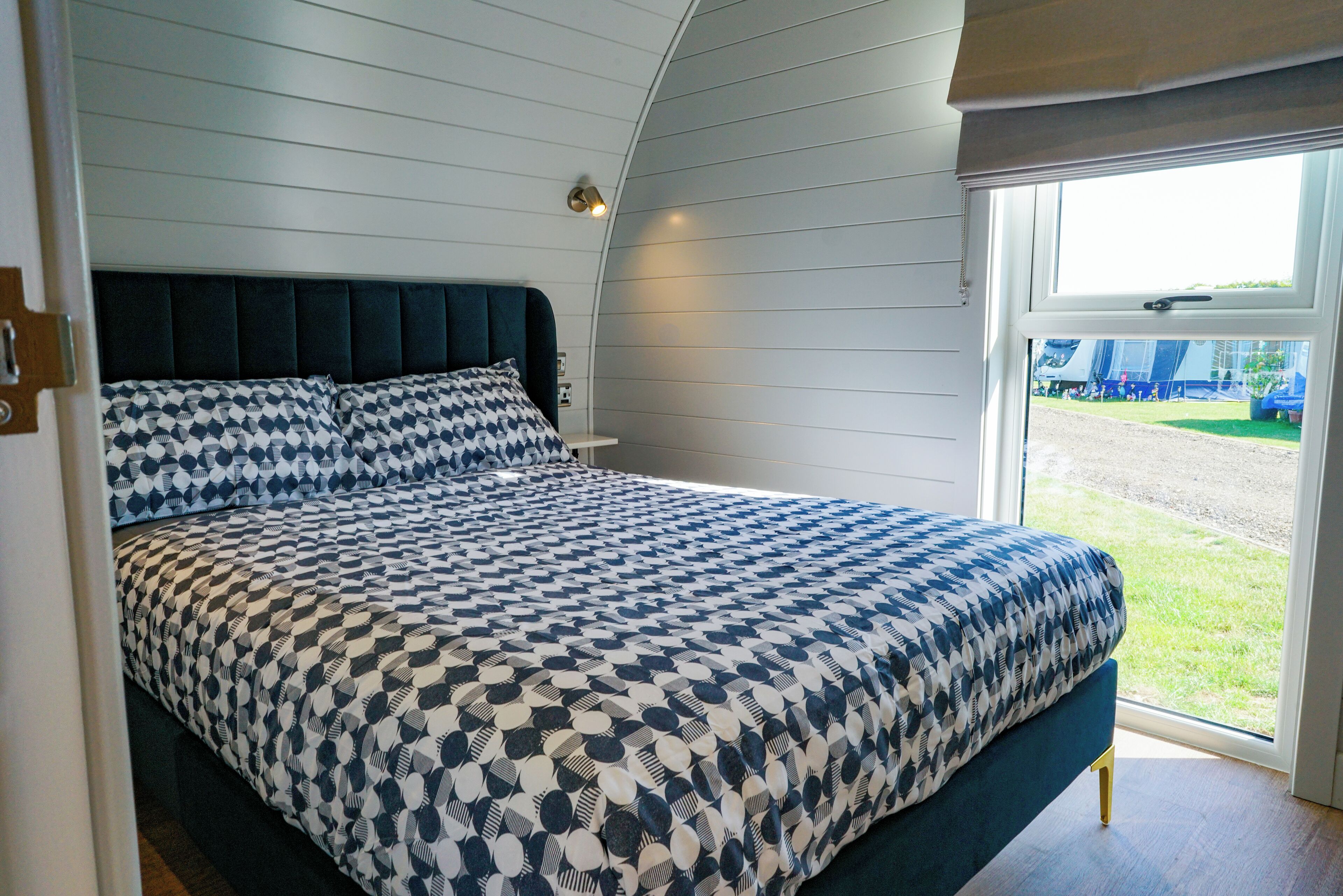 A bedroom with a bed, a window, and a view of the outside.