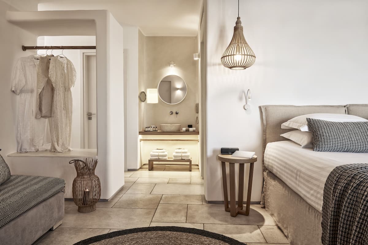 Een moderne slaapkamer met een bed, nachtkastje en een hanglamp.