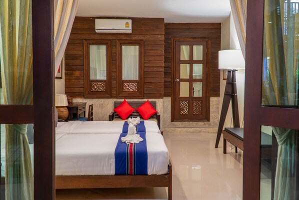 Una habitación de hotel con cama, escritorio, lámpara y banca.